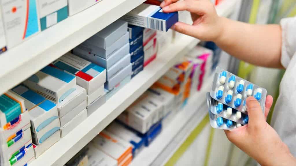 pharmacist holding medicine box and capsule pack