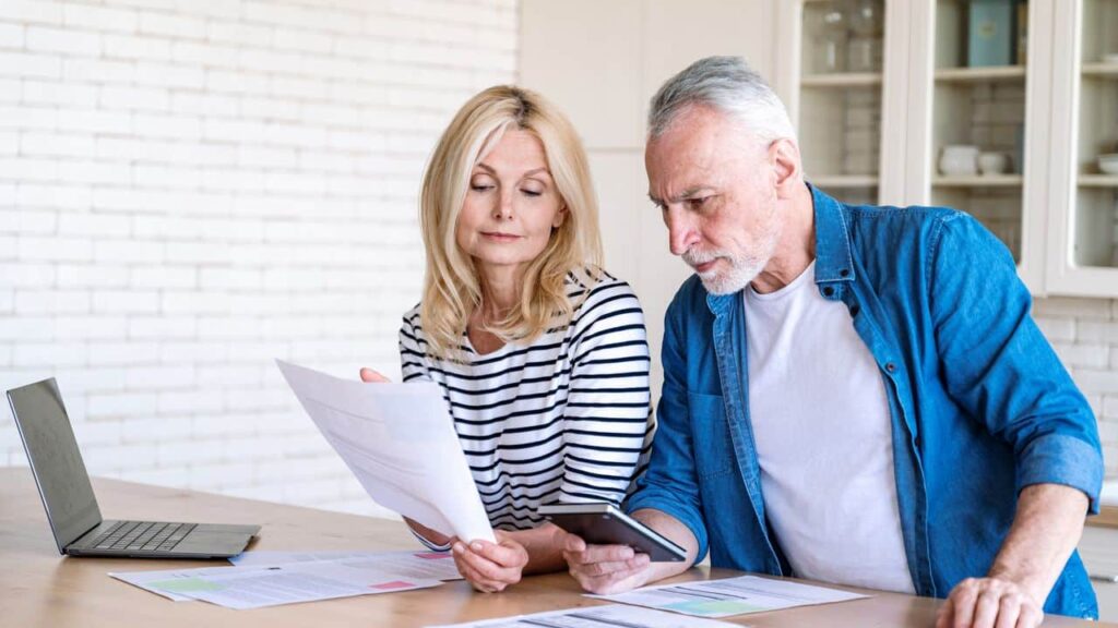 worried middle aged man and woman paying utility bill online