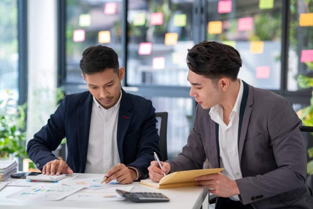 analystes financiers comparant les résultats de différentes filiales sur ordinateur
