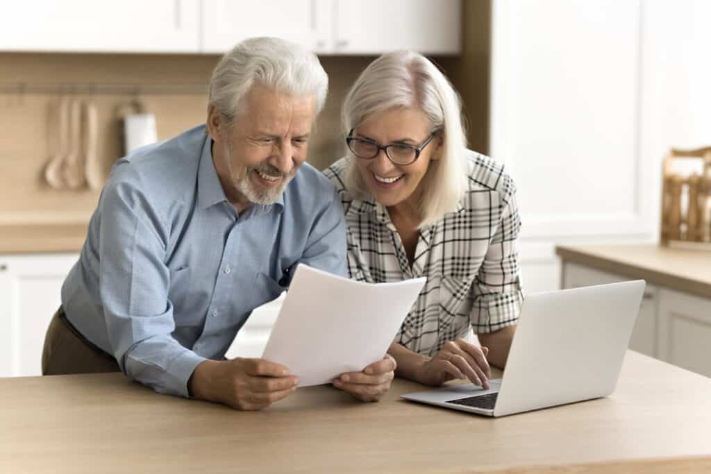 happy satisfied senior retired couple reading legal document