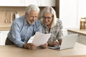 happy satisfied senior retired couple reading legal document
