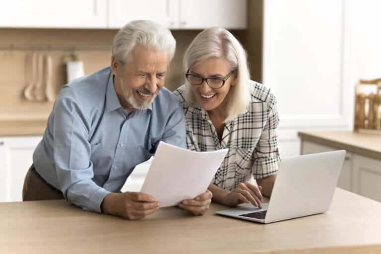 happy satisfied senior retired couple reading legal document