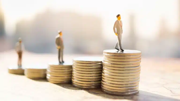 miniature,people:,small,figure,standing,on,stack,of,coin.,money