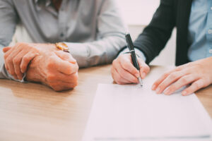 unrecognizable woman signing contract at meeting tone