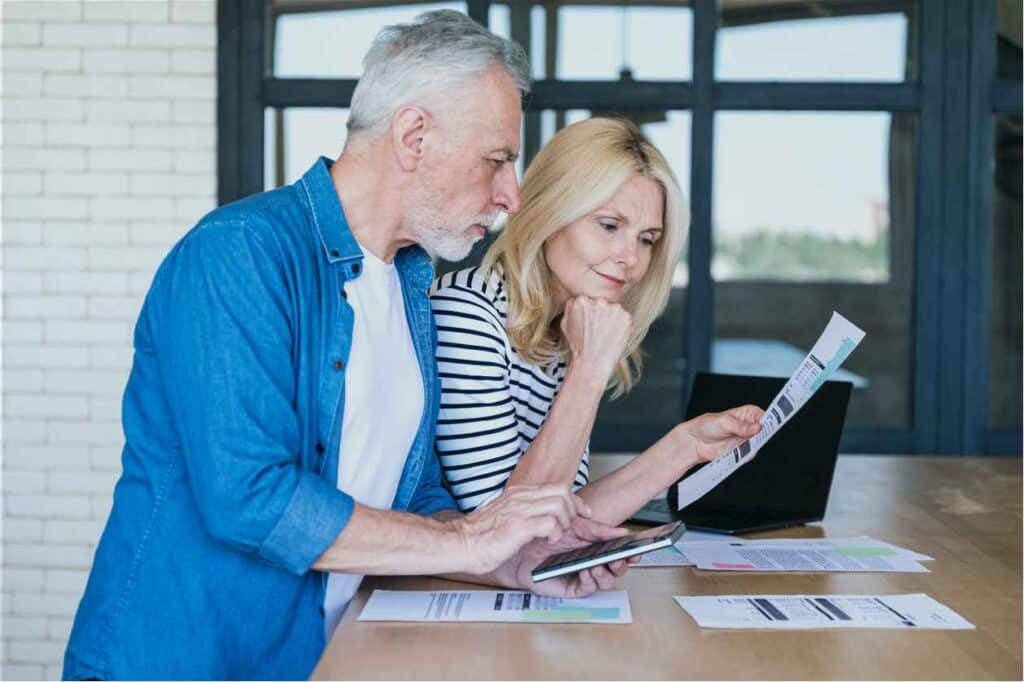 mature husband and wife planning monthly budget together