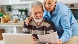 senior,couple,checking,bills,and,calculating,expenses,using,a,laptop