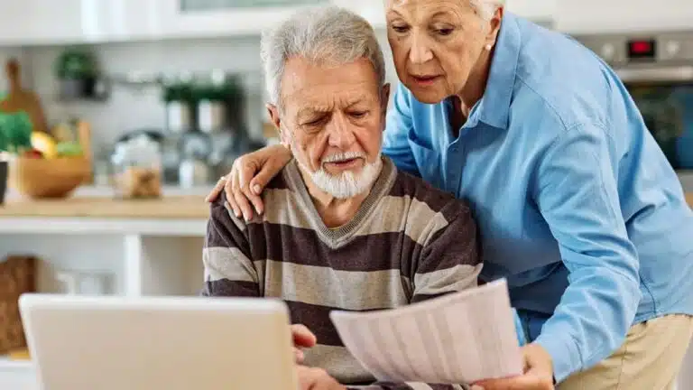 senior,couple,checking,bills,and,calculating,expenses,using,a,laptop